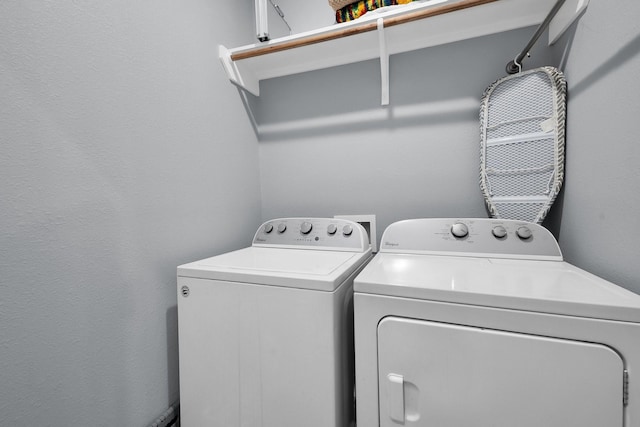 clothes washing area featuring laundry area and washer and clothes dryer