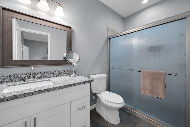 full bathroom with toilet, a shower stall, and vanity