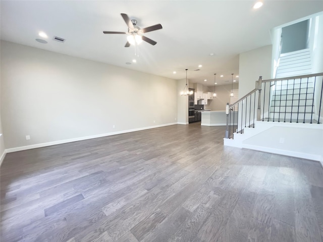 unfurnished living room featuring stairway, recessed lighting, dark wood finished floors, and baseboards