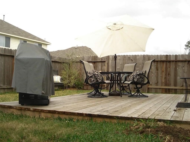 wooden terrace featuring a grill and fence