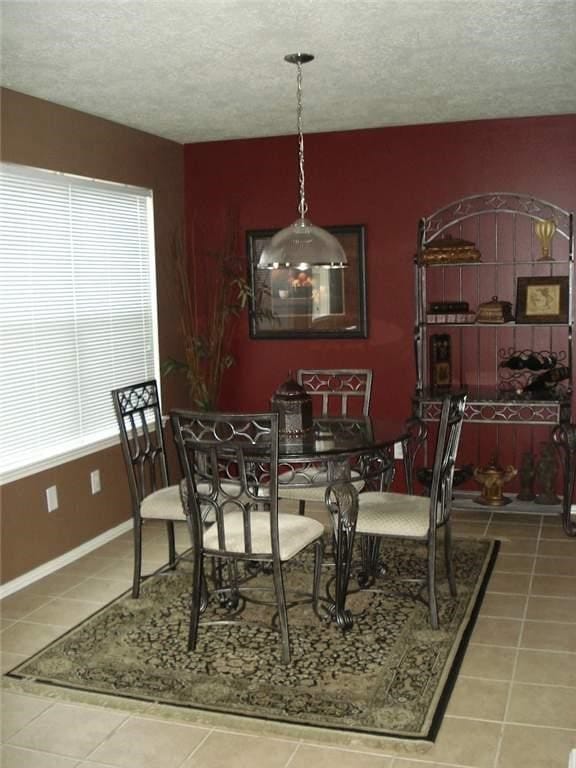 tiled dining space with a textured ceiling