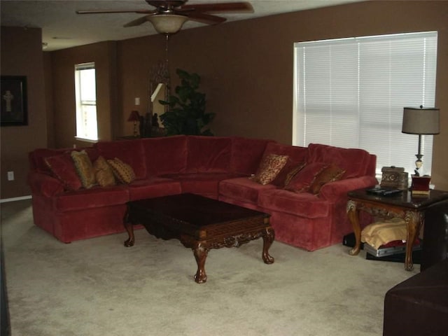 living area featuring carpet flooring and ceiling fan