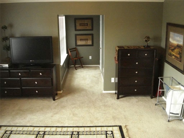 bedroom with baseboards and light colored carpet