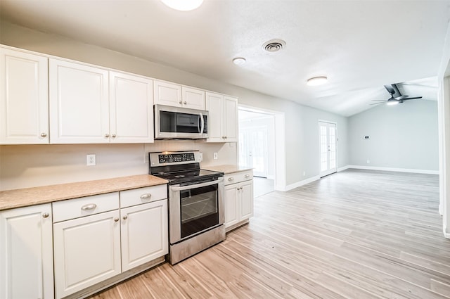 kitchen featuring appliances with stainless steel finishes, visible vents, light wood-style flooring, and white cabinetry