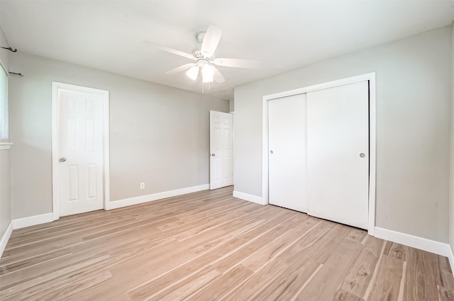 unfurnished bedroom with light wood-style floors, a closet, and baseboards