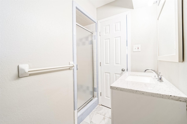 bathroom with marble finish floor, a shower stall, and vanity