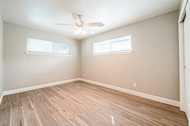 spare room featuring ceiling fan, light wood-type flooring, and baseboards