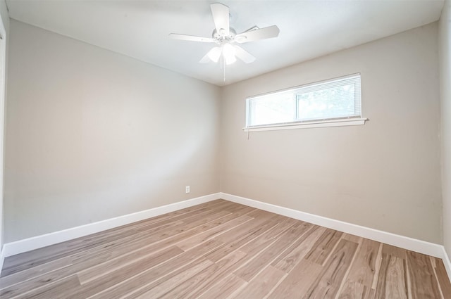 spare room with light wood-type flooring, baseboards, and a ceiling fan