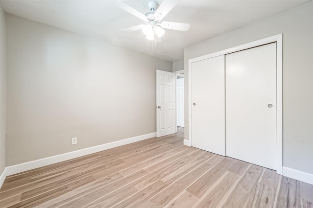 unfurnished bedroom featuring a ceiling fan, a closet, light wood-style flooring, and baseboards