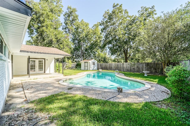 view of pool with french doors, a patio, a shed, a fenced backyard, and an outdoor structure