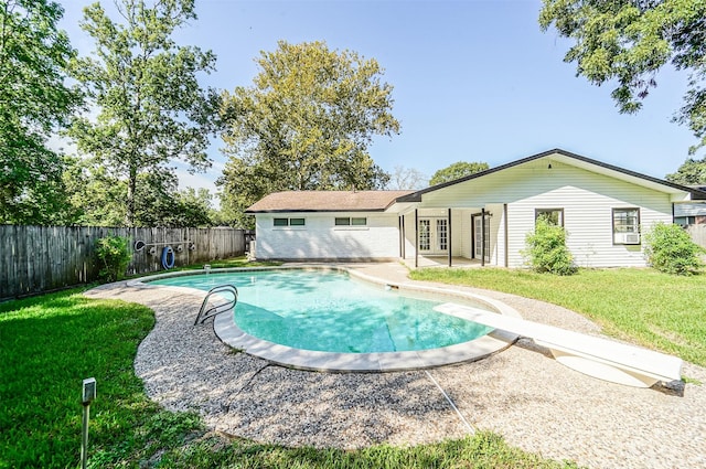 back of house featuring a fenced in pool, french doors, a patio, a lawn, and a fenced backyard