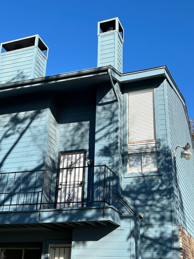 view of side of property featuring a balcony and a chimney