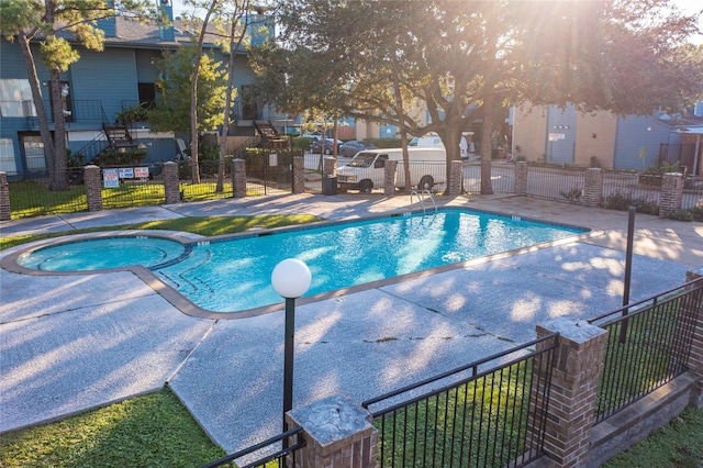 view of swimming pool featuring a residential view, a patio area, fence, and a pool with connected hot tub