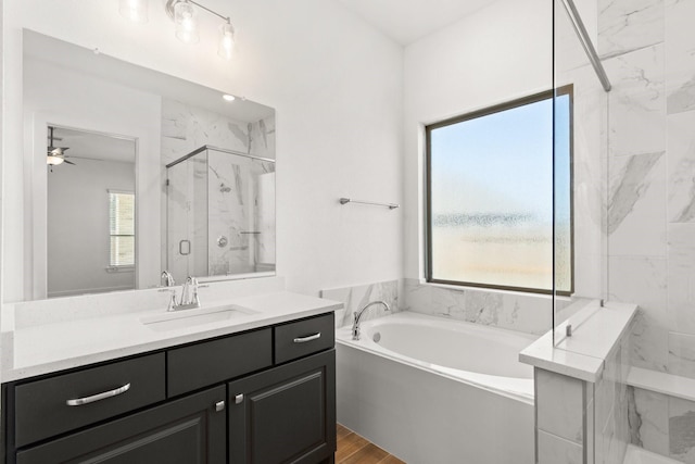 full bathroom with a garden tub, a marble finish shower, wood finished floors, and vanity