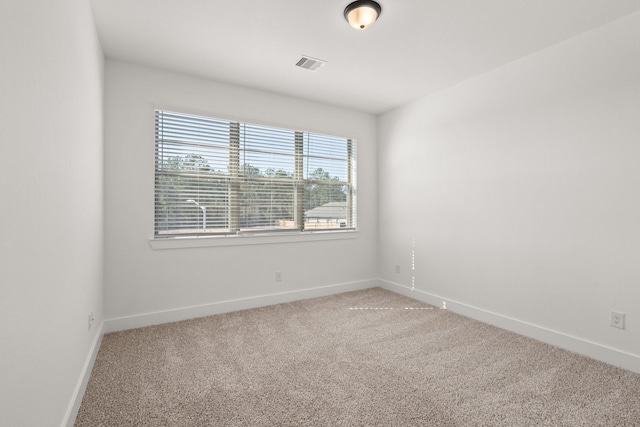 carpeted empty room featuring visible vents and baseboards