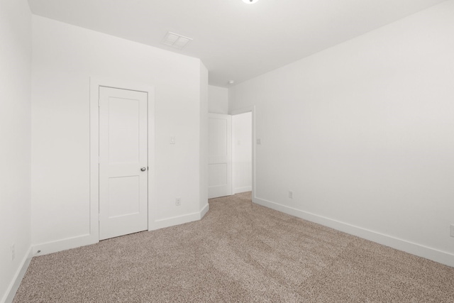 unfurnished bedroom featuring light carpet and baseboards