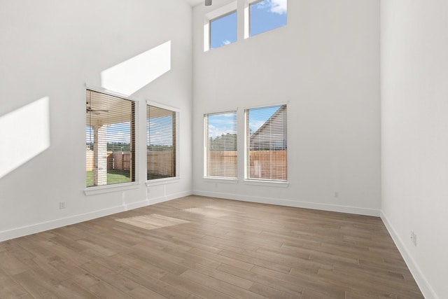 interior space featuring a healthy amount of sunlight, baseboards, and wood finished floors