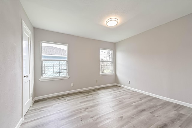 unfurnished room featuring light wood finished floors and baseboards