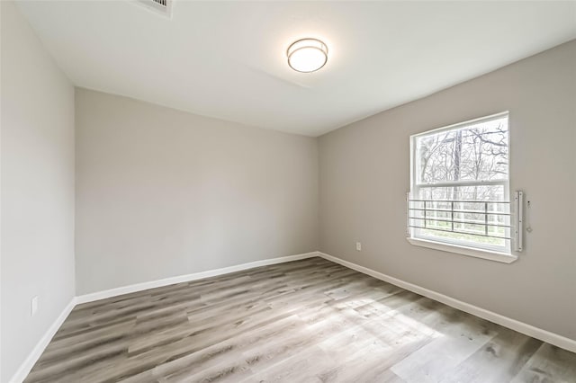 unfurnished room with wood finished floors and baseboards