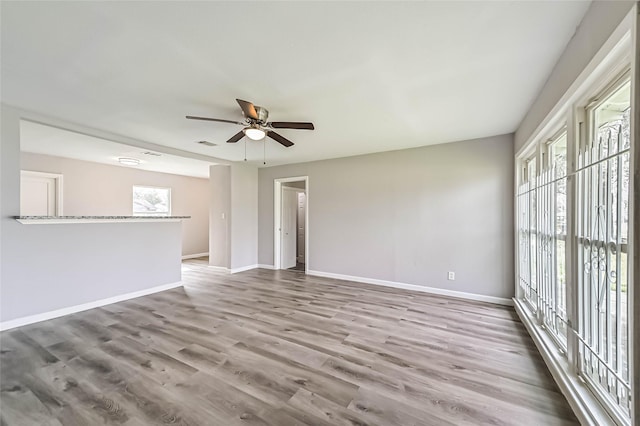 unfurnished room with visible vents, ceiling fan, baseboards, and wood finished floors