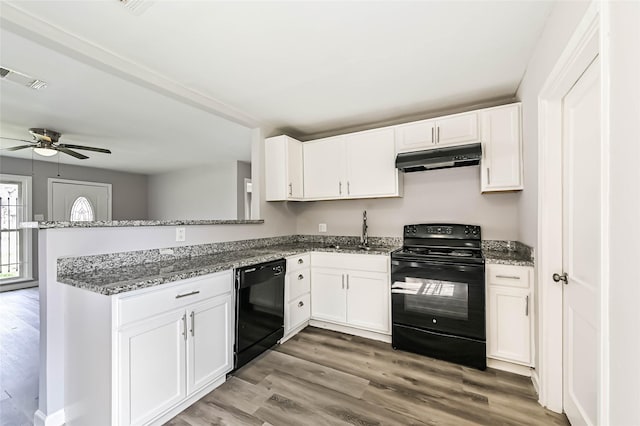 kitchen with visible vents, white cabinets, under cabinet range hood, black appliances, and a sink