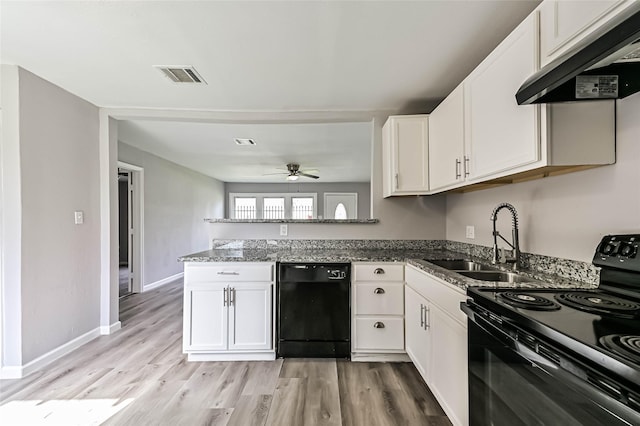 kitchen featuring visible vents, a sink, a peninsula, under cabinet range hood, and black appliances