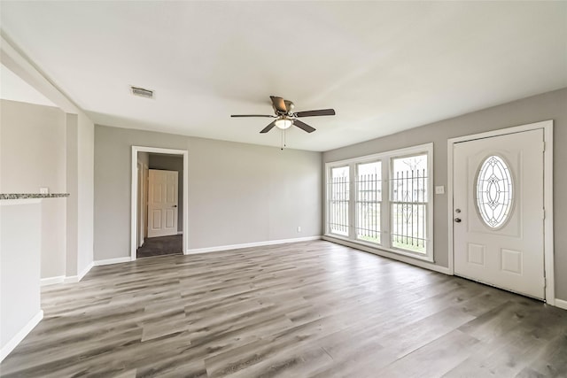 foyer with visible vents, ceiling fan, baseboards, and wood finished floors