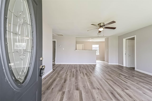 entryway with ceiling fan, baseboards, and wood finished floors