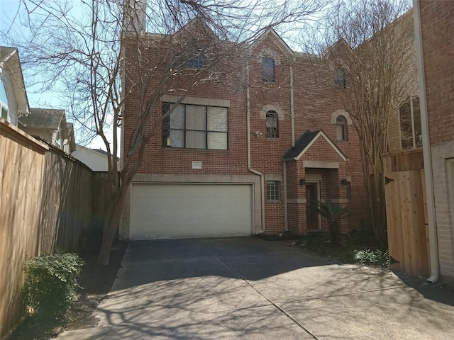 view of front facade with driveway, a garage, fence, and brick siding