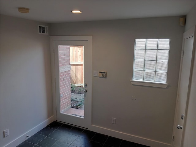 doorway featuring dark tile patterned floors, visible vents, baseboards, and recessed lighting