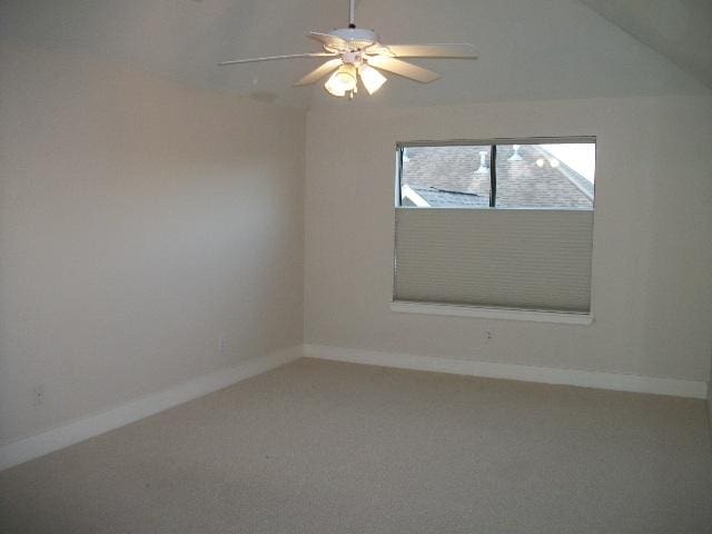 empty room featuring ceiling fan, baseboards, vaulted ceiling, and carpet flooring