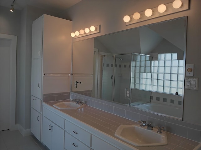 bathroom with tile patterned flooring, a sink, a shower stall, and double vanity