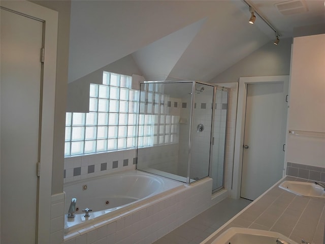 bathroom featuring a sink, vaulted ceiling, a shower stall, a whirlpool tub, and plenty of natural light