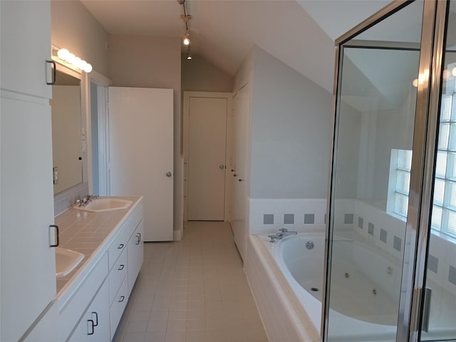 bathroom featuring tile patterned flooring, a sink, vaulted ceiling, a jetted tub, and double vanity