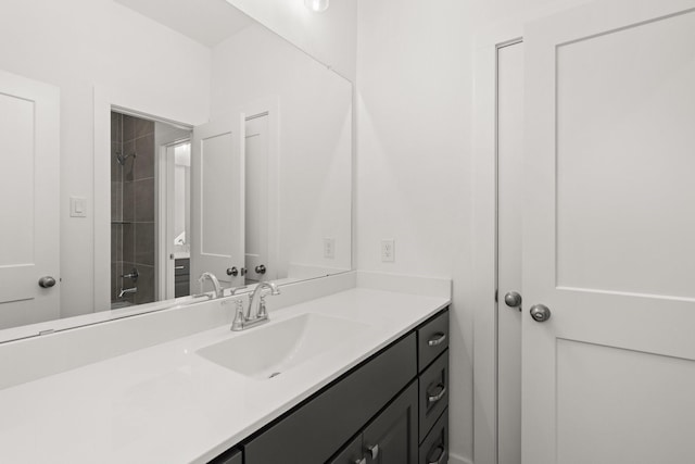 bathroom featuring a tile shower and vanity