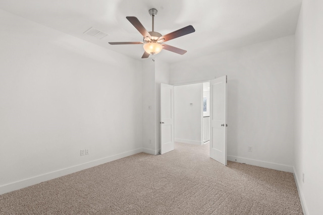 unfurnished bedroom with a ceiling fan, light colored carpet, visible vents, and baseboards