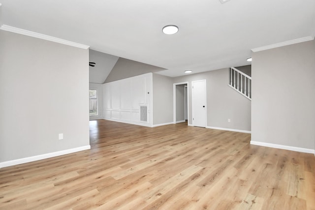 spare room featuring crown molding, stairway, baseboards, and wood finished floors