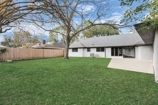 view of yard featuring central AC unit, a patio area, and a fenced backyard