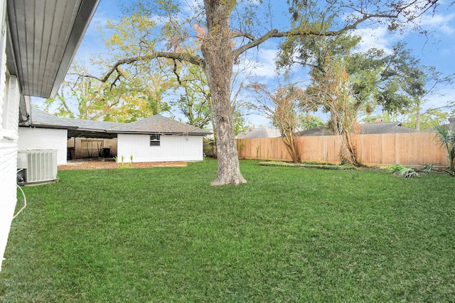 view of yard with central AC unit and fence