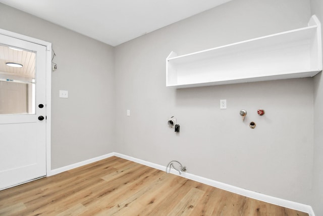 clothes washing area with laundry area, gas dryer hookup, light wood-type flooring, and baseboards