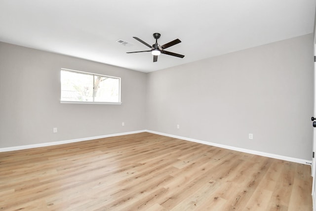 spare room with light wood finished floors, visible vents, baseboards, and a ceiling fan