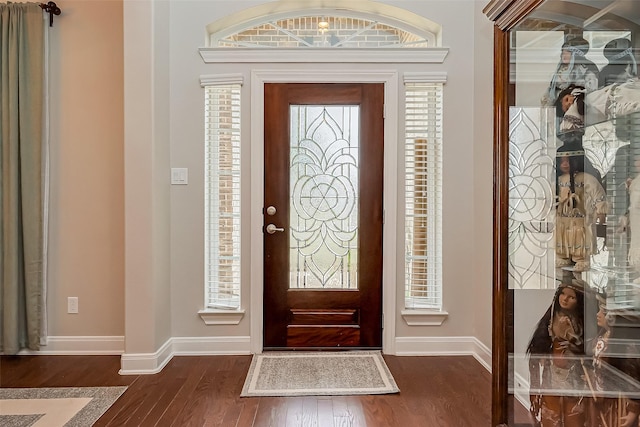 foyer with dark wood-style floors and baseboards