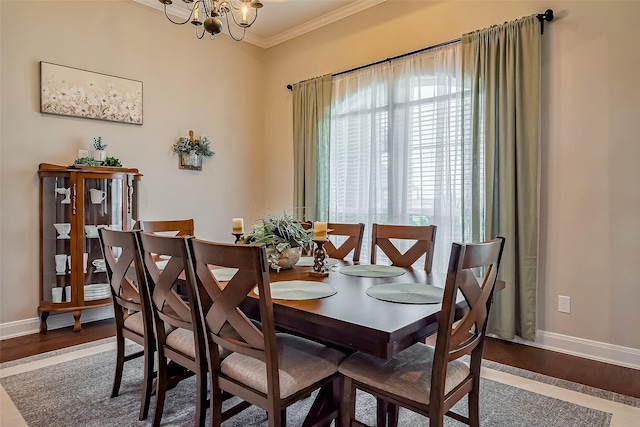 dining room with baseboards, crown molding, an inviting chandelier, and wood finished floors