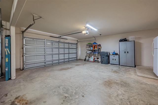 garage featuring freestanding refrigerator and a garage door opener