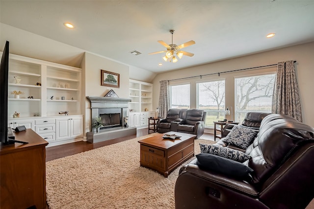 living area featuring visible vents, dark wood finished floors, a ceiling fan, a tiled fireplace, and recessed lighting