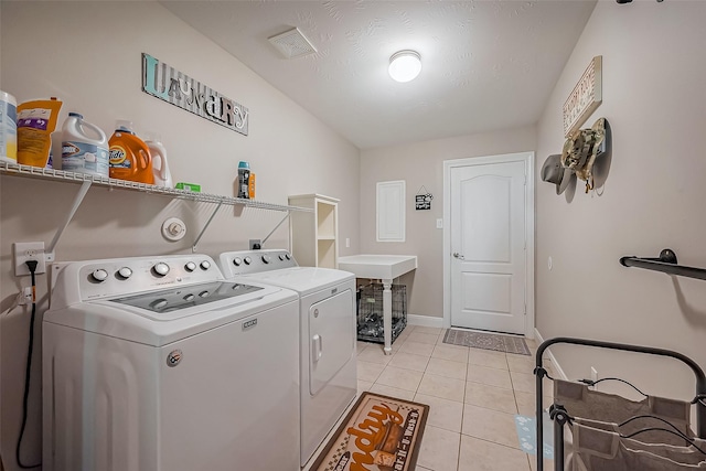 laundry area with laundry area, light tile patterned floors, baseboards, visible vents, and washer and clothes dryer