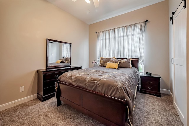 carpeted bedroom featuring a barn door, baseboards, and ceiling fan