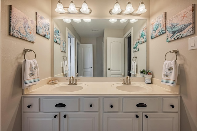 bathroom with double vanity, visible vents, and a sink