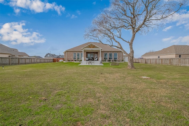 rear view of property with ceiling fan, a fenced backyard, brick siding, a lawn, and a patio area