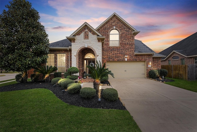 traditional-style home with brick siding, driveway, a front yard, and fence